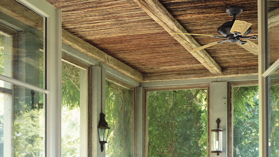 screened in porch with table and wicker chairs