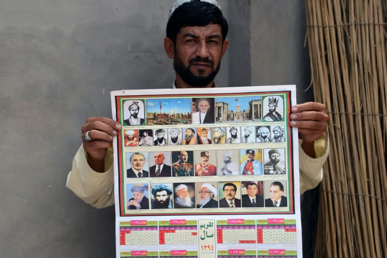 A man holds a calendar bearing the images of Afghan leaders including the Taliban's late chief Mullah Omar (bottom, 2L) in Kandahar, Afghanistan on July 31, 2015