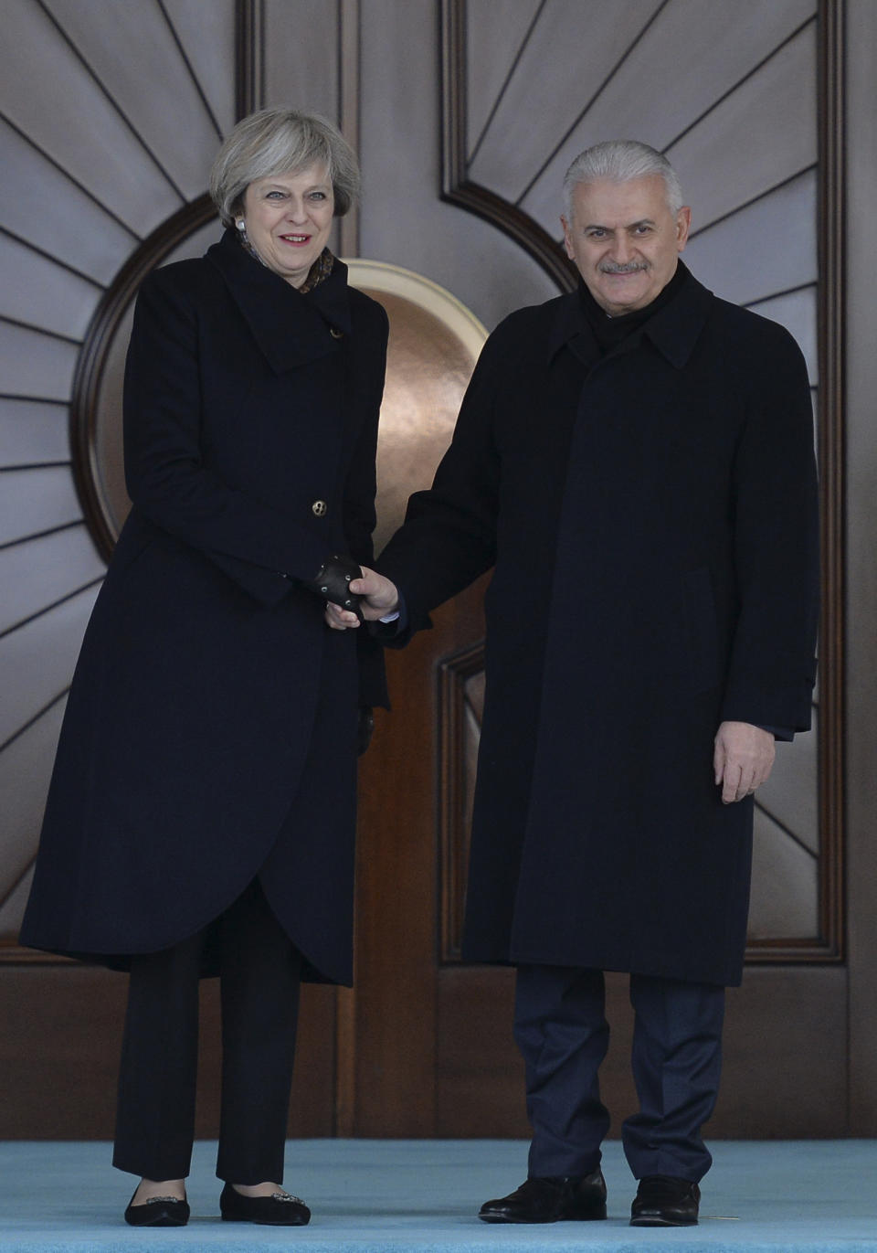 Turkey's Prime Minister Binali Yildirim, right, shakes hands with British Prime Minister Theresa May, left, prior to their meeting in Ankara, Turkey, Saturday, Jan. 28, 2017. May on Saturday urged Turkey to sustain its democracy and abide by human rights standards during her meeting with Turkish President Recep Tayyip Erdogan that also drew promises of closer defense cooperation between the two NATO allies. (AP Photo)