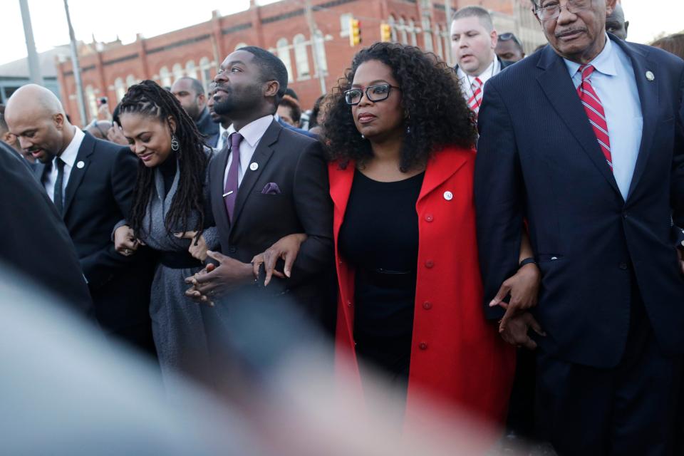 Oprah Winfrey locks arms with David Oyelowo, who portrays the Rev. Martin Luther King Jr. in the movie “Selma,” Ava DuVernay, the director of “Selma” and rapper/actor Common, far left, in Selma, Ala.