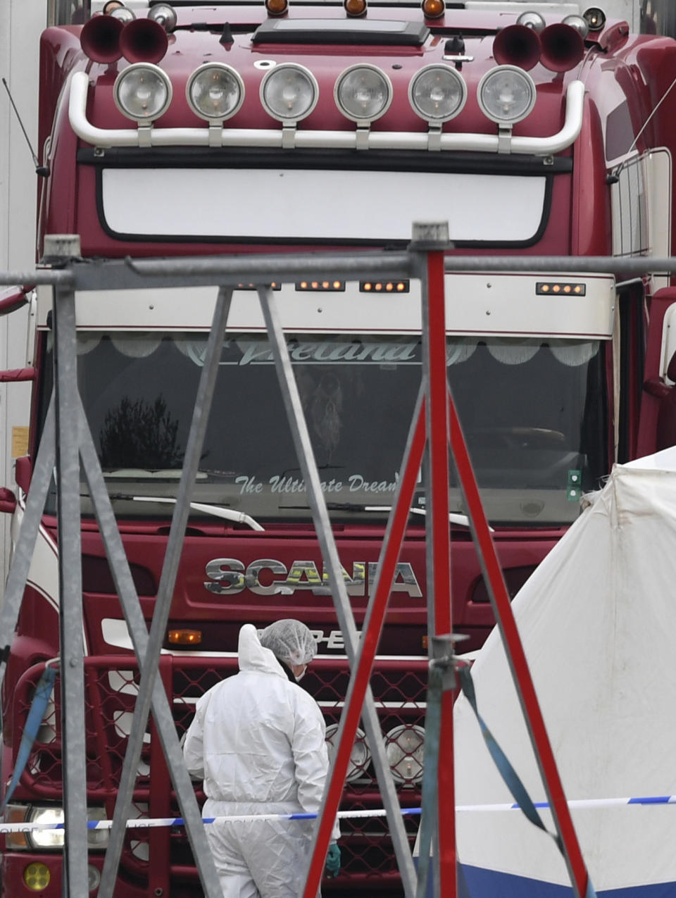 Police attend the scene after a truck was found to contain 39 dead bodies inside the truck in Thurrock, South England, early Wednesday Oct. 23, 2019. The truck is thought to have entered Britain at the Welsh port of Holyhead on Saturday, and was found by ambulance workers at Waterglade Industrial Park in Grays, near Thurrock, England, around 25 miles (40 kms) east of central London. (Stefan Rousseau/PA via AP)