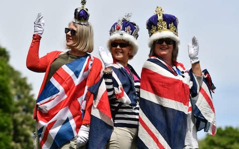 Royal fans bedecked with Union flags and crowns pose for a photograph on the Long Walk in Windsor  - Credit: Ben Stansall/AFP