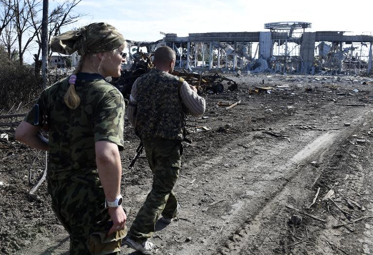 Pro-Russian militants walk in front of the remains of Lugansk International Airport, eastern Ukraine, on September 11, 2014