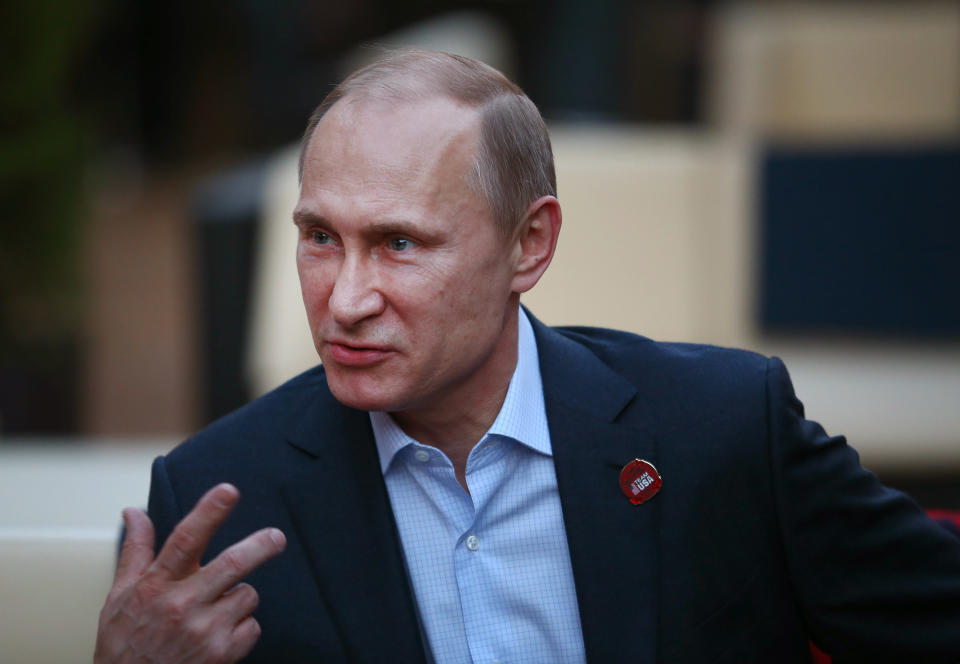 Russian President Vladimir Putin gestures while visiting USA House in the Olympic Village during the 2014 Winter Olympics on Friday, Feb. 14, 2014, in Sochi, Russia. (AP Photo/Marianna Massey, USOC Pool)