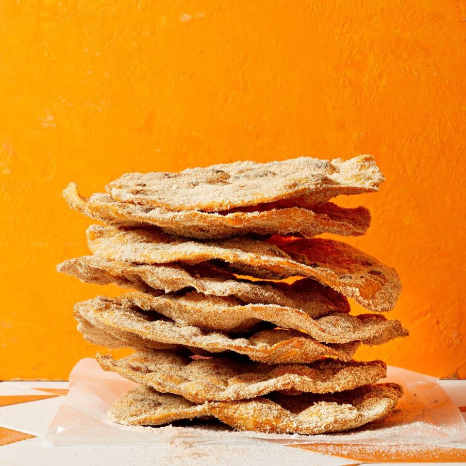 a stack of bunuelos with orange background
