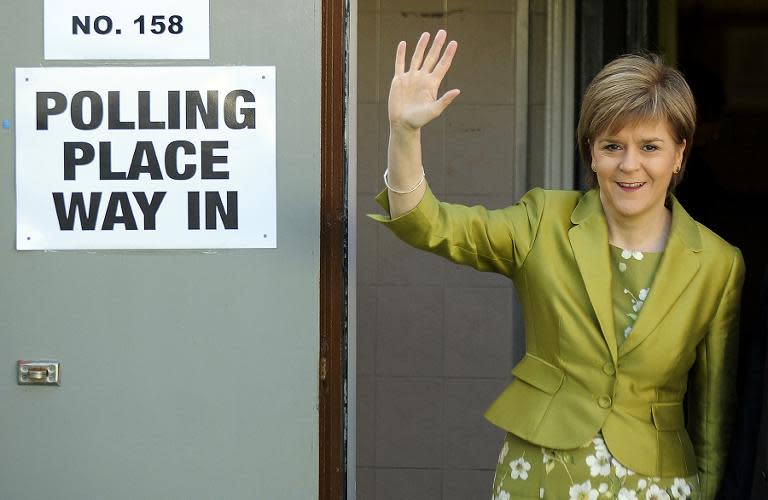 Nicola Sturgeon waves after casting her vote at the Broomhoouse Community Hall in Glasgow on May 7, 2015