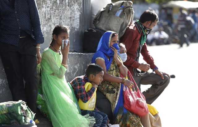 A migrant family wait for transportation to travel to their respective villages following a lockdown amid concern over the spread of coronavirus in New Delhi, India 