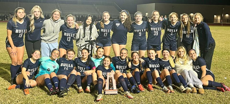 The Parrish Community High girls soccer team poses with the championship trophy after defeating Braden River High, 2-1, for the Class 5A-District 10 title. It was the Bulls third straight district crown.