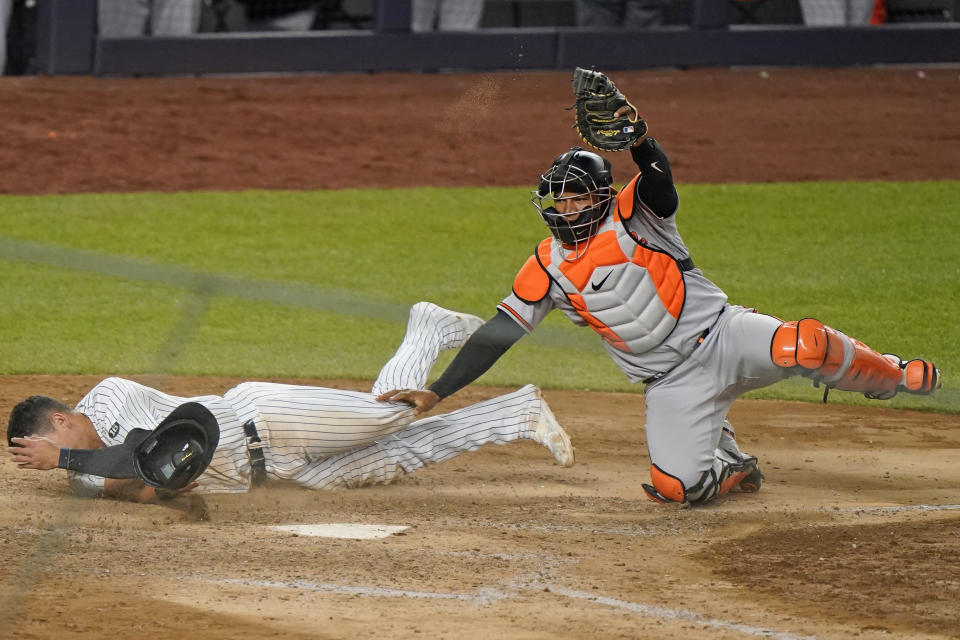 Baltimore Orioles catcher Pedro Severino holds up his glove with the ball in it after tagging out New York Yankees' Gio Urshela during the 11th inning of a baseball game Wednesday, April 7, 2021, at Yankee Stadium in New York. (AP Photo/Kathy Willens)