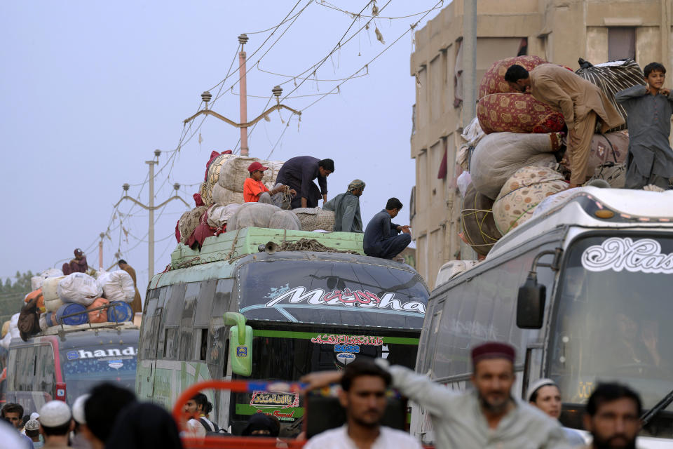 Afghans load their belongings on the rooftop of a bus as they prepare to depart for their homeland, in Karachi, Pakistan, Wednesday, Nov. 1, 2023. Pakistani security forces on Wednesday rounded up, detained and deported dozens of Afghans who were living in the country illegally, after a government-set deadline for them to leave expired, authorities said. (AP Photo/Fareed Khan)