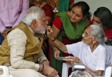 Hindu nationalist Narendra Modi (L), the prime ministerial candidate for the main opposition Bharatiya Janata Party (BJP), seeks blessings from his mother Heeraben at her residence in Gandhinagar, in Gujarat May 16, 2014. REUTERS/Amit Dave