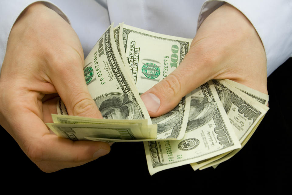 Man counting hundred-dollar bills