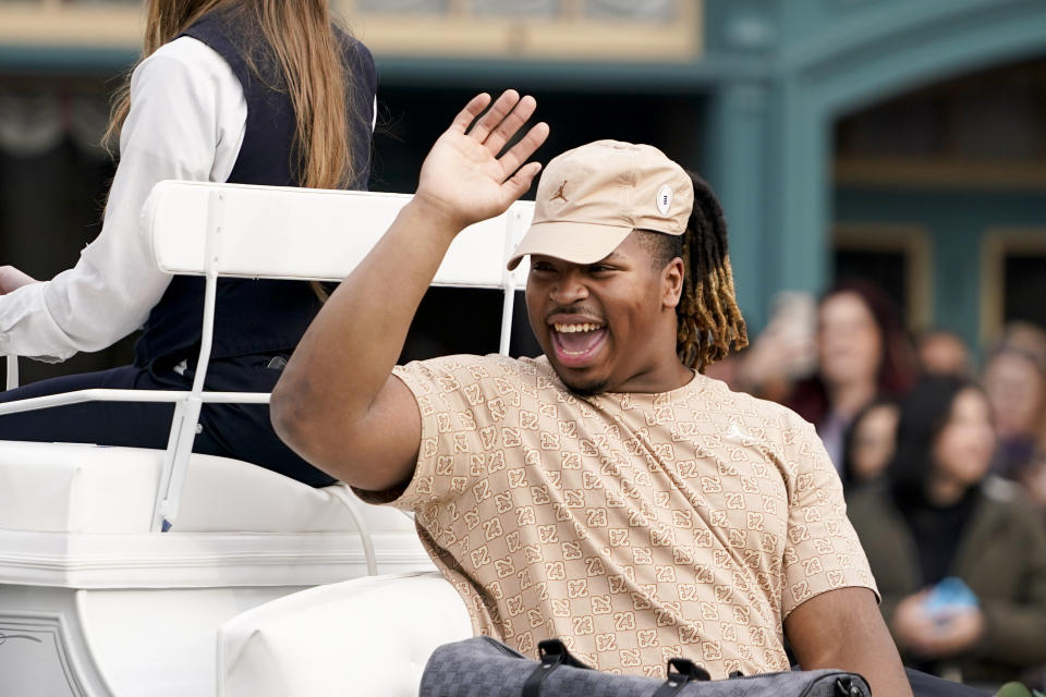 Michigan defensive lineman Kris Jenkins waves during a welcome event for the team at Disneyland on Wednesday, Dec. 27, 2023, in Anaheim, Calif. Michigan is scheduled to play against Alabama on New Year's Day in the Rose Bowl, a semifinal in the College Football Playoff. (AP Photo/Ryan Sun)