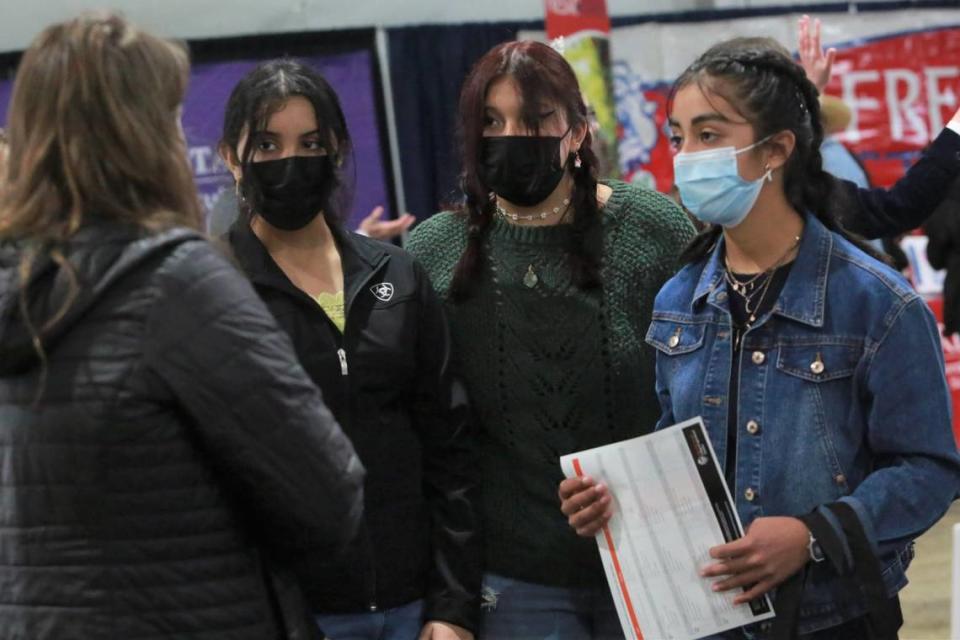 Chowchilla High School freshmen Kathrine Bugarin, Karina Sánchez, and Gabriela Vasquez get information at one of the booths inside the Ag Career and Education tent at the World Ag Expo on Tuesday, Feb. 8, 2022. 