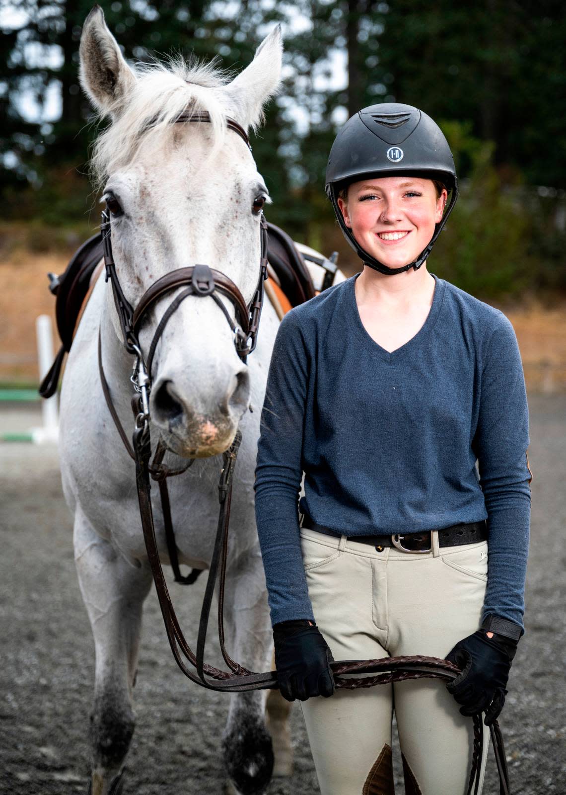 Emerald Ridge High School sophomore Emily Bingham poses for a portrait with her horse, Q It Up, at Signature West Farms LLC in Spanaway, Wash. on Sept. 22, 2022. Bingham was nominated by the Washington State Hunter Jumper Association for the Marshall & Sterling Insurance/USHJA National Championships, a competition for riders in the country to earn national titles.