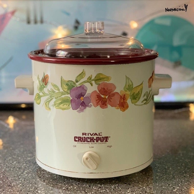 A white crock-pot with watercolor flowers on it