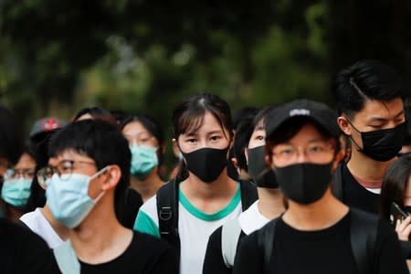 People and alumni of Tsuen Wan Public Ho Chuen Yiu Memorial College participate in a student gathering in the school in solidarity with the student protester who was shot by a policeman on Tuesday in Tsuen Wan