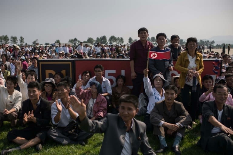 Spectators watch as a Hughes MD-500 helicopter performs a fly-by during the first Wonsan Friendship Air Festival