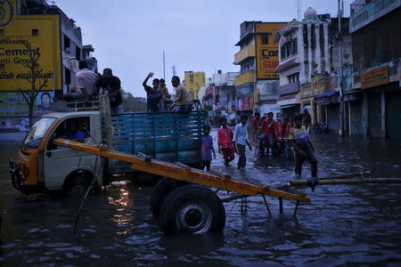 People commute through a flooded street in Chennai, India, December 3, 2015. REUTERS/Anindito Mukherjee