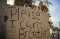 A protester holds a sign during a protest to decry the killing of George Floyd in front of the American embassy in Tel Aviv, Israel, Tuesday, June 2, 2020.(AP Photo/Ariel Schalit)