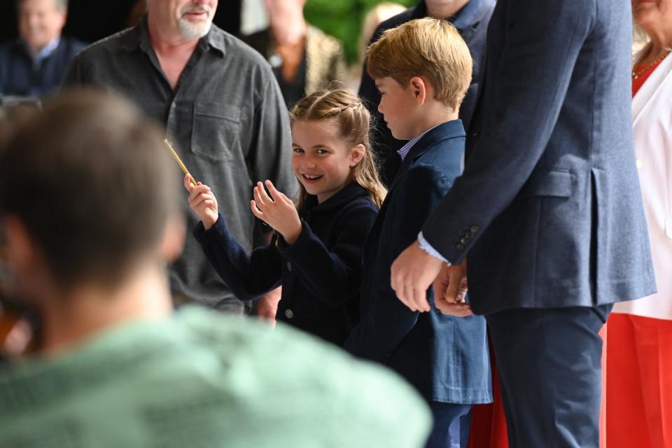 Princess Charlotte laughs as she conducts a band next to her brother, Prince George,  during their visit to Cardiff Castle to meet performers and crew involved in the special Platinum Jubilee Celebration Concert (PA)