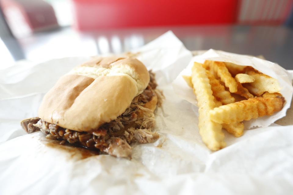 The pulled pork shoulder sandwich with fries combo can be seen on a table inside of A & R Bar-B-Q, which is famous for its pulled pork sandwiches, as well as its rib sandwich. The Memphis barbecue restaurant was named by Southern Living as the 11th best barbecue restaurant in the country on its 2023 list of top 50 BBQ Joints