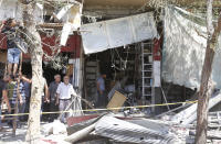 <p>Syrians inspect the damage at the site of a suicide bomb attack in the capital Damascus’ eastern Tahrir Square district, on July 2, 2017. (Louai Beshara/AFP/Getty Images) </p>