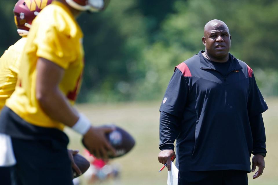 Washington Commanders assistant head coach/offensive coordinator Eric Bieniemy watches quarterback drills during Commanders rookie minicamp at Commanders Park.