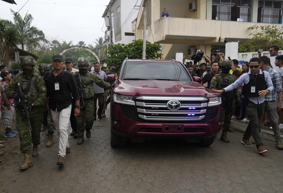 Soldados y elementos de seguridad escoltan el auto del candidato presidencial ecuatoriano Daniel Noboa tras haber votado en la segunda vuelta electoral en la localidad de Olón, Ecuador, el domingo 15 de octubre de 2023. (AP Foto/Martín Mejía)