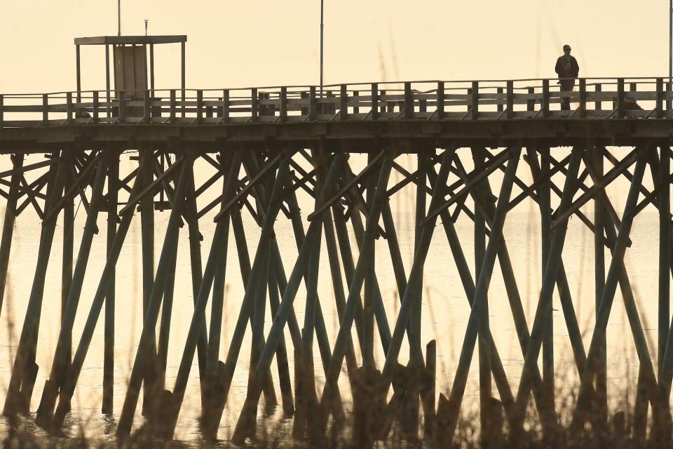 People walk along the Kure Beach Pier in 2022.