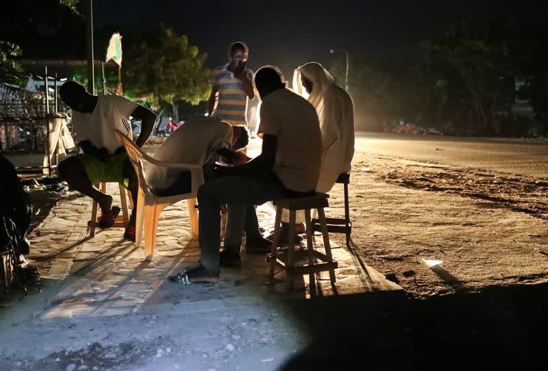 People are seen outside their home after tremors shook buildings, following Saturday's earthquake in Les Cayes, Haiti