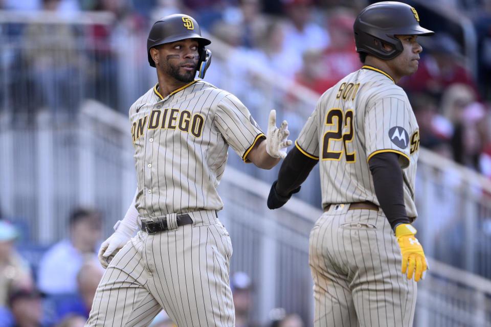 San Diego Padres' Xander Bogaerts, left, is greeted by Juan Soto (22) after they both scored on a double by Rougned Odor during the fifth inning of a baseball game against the Washington Nationals, Thursday, May 25, 2023, in Washington. (AP Photo/Nick Wass)