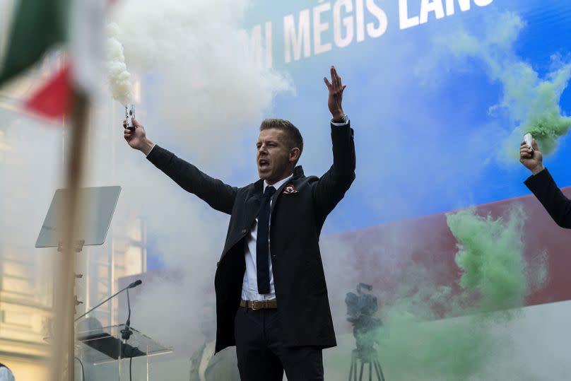 Péter Magyar, the former husband of one-time justice minister and Orbán ally Judit Varga holds a smoke-candle after his speech on Hungary's National Day in Budapest.