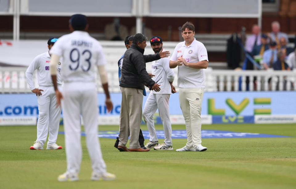 LONDON, ENGLAND - AUGUST 14: A spectator dressed in an India shirt and whites, makes his way onto the field before being escorted off the field before the afternoon session during day three of the Second Test Match between England and  India at Lord's Cricket Ground on August 14, 2021 in London, England. (Photo by Stu Forster/Getty Images)