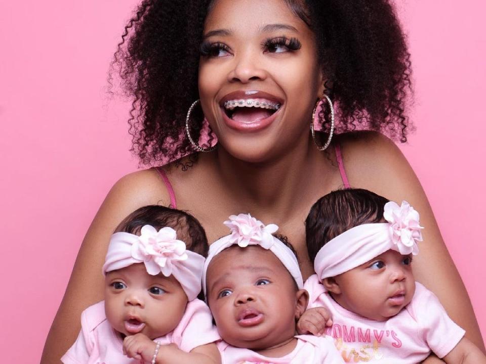 Woman holding three babies