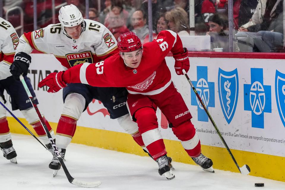 Detroit Red Wings right wing Alex DeBrincat (93) is defended by Florida Panthers center Anton Lundell (15) during the third period at Little Caesars Arena in Detroit on Thursday, Nov. 2, 2023.