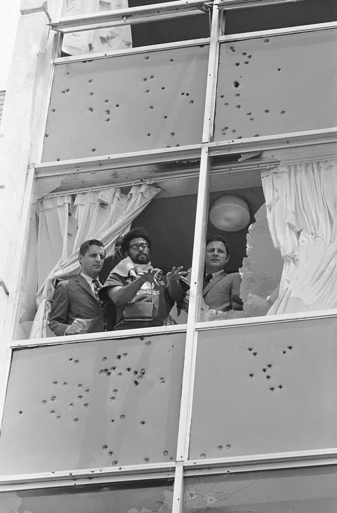 In this May 20, 1970, file photo, U.S. Sens. Walter Mondale, D-Minn., left, and Birch Bayh, D-Ind., right, look from the shattered windows of Alexander Hall, a women’s dormitory, during a visit to Jackson State College, in Jackson, Miss., days after an assault by local white police and members of the Mississippi Highway Patrol, who claimed they had seen a sniper. Pointing out the view is student Carl Griffin. The historically Black school canceled its 1970 commencement after the violent incident. Fifty-one years later, the school now called Jackson State University is honoring its Class of 1970, as members are being invited back to salute their academic achievements with a graduation ceremony on Saturday, May 15, 2021. (AP Photo, File)