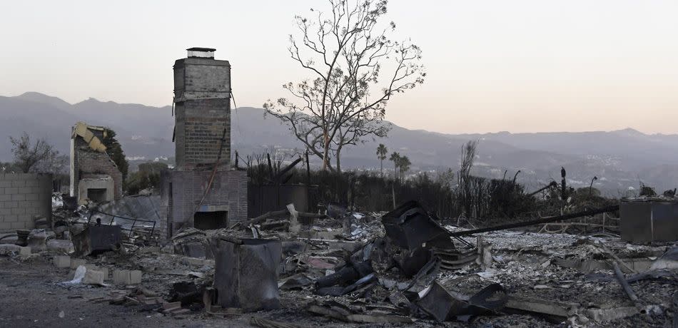 Destroyed houses are seen with the Santa Monica Mountains in the background on November 12, 2018 in Malibu, California, as the Woolsey Fire continues to burn