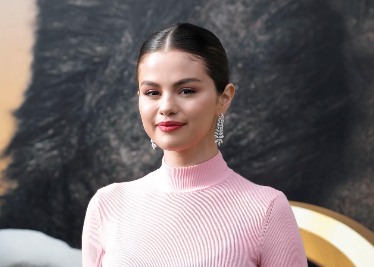 Selena Gomez smolders at the camera wearing a pink turtle neck