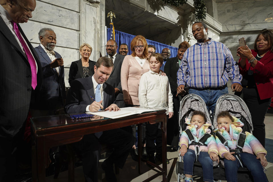 Kentucky Democratic Governor Andy Beshear signs an executive order to reinstate the voting rights of over 100,000 non-violent felons who have completed their sentences, at the Capitol in Frankfort, Ky., Thursday, Dec. 12, 2019. (AP Photo/Bryan Woolston)