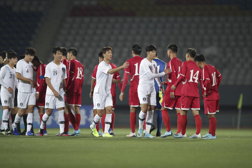 In this photo provided by the Korea Football Association, South Korean players, wearing white, shake hands with North Korean players after Asian zone Group H qualifying soccer match for the 2022 World Cup at Kim Il Sung Stadium in Pyongyang, North Korea, Tuesday, Oct. 15, 2019. (The Korea Football Association via AP)