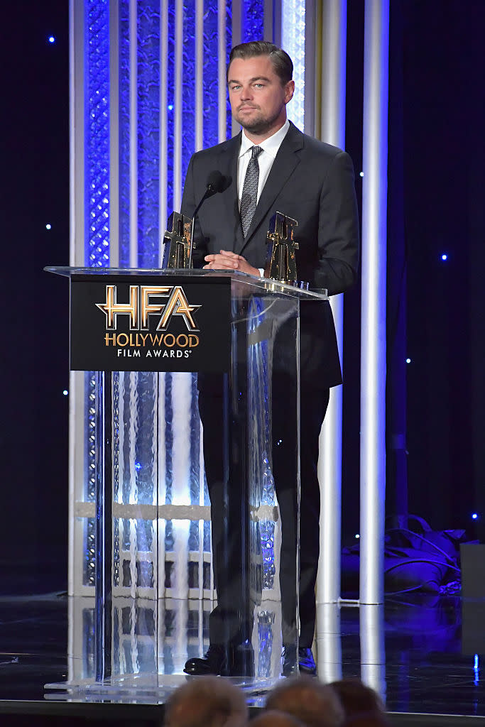 Leonardo DiCaprio accepting an award in a gray suit