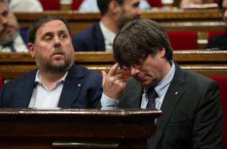 Catalan regional President Carles Puigdemont (R) gestures next to the vice president Oriol Junqueras during a debate in the Catalonian regional Parliament in Barcelona, Spain, September 7, 2017. REUTERS/Albert Gea