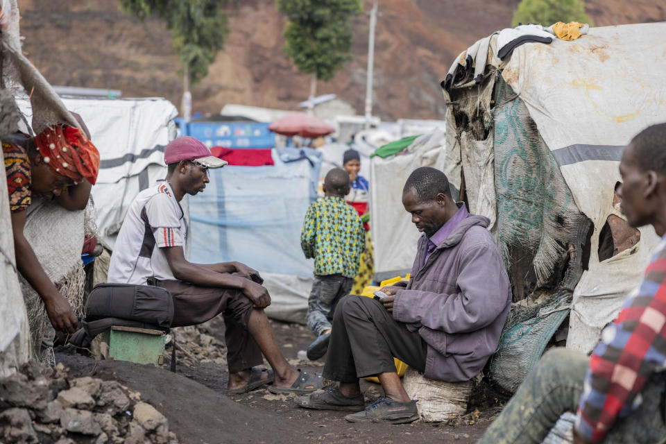 Displaced Congolese sit outside their tents in the Kanyaruchinya camp outside Goma, eastern Democratic Republic of the Congo, Saturday, Dec. 9, 2023. As Congo prepares to hold elections on Dec. 20, a record 6.9 million people are internally displaced across the vast Central African nation, according to the United Nations. (AP Photo/Moses Sawasawa)