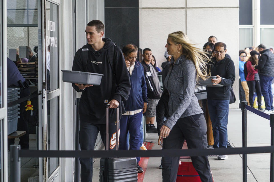 Marni Larsen and her son, Damon Rasmussen of Holladay, Utah, walk-in to process her son's passport after waiting in line for hours outside the Los Angeles Passport Agency at the Federal Building in Los Angeles on Wednesday, June 14, 2023. Larsen applied for her son's passport two months earlier and spent weeks checking for updates online or through a frustrating call system. (AP Photo/Damian Dovarganes)