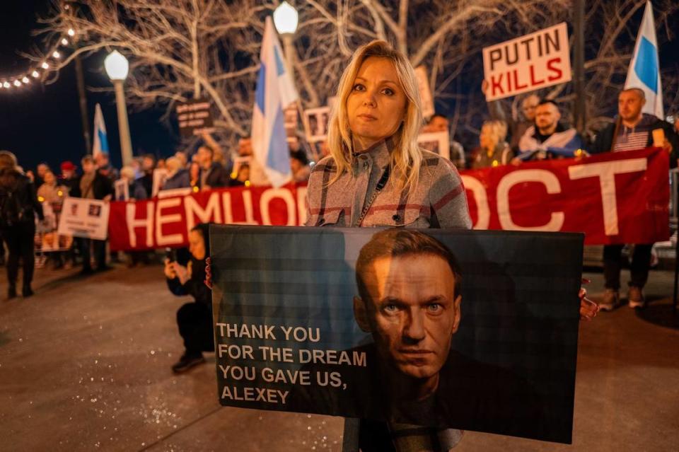 Iana Trotsiuk holds a sign in memory of Russian opposition leader Alexei Navalny, who died in an Arctic penal colony earlier this month, at a candlelight vigil along the Sacramento waterfront on Tuesday.