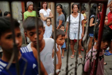 People gather outside the house where Noberto Maderal and fellow pedicab driver George Avancena were killed during a drug-related police operation in Manila, Philippines October 19, 2016. REUTERS/Damir Sagolj