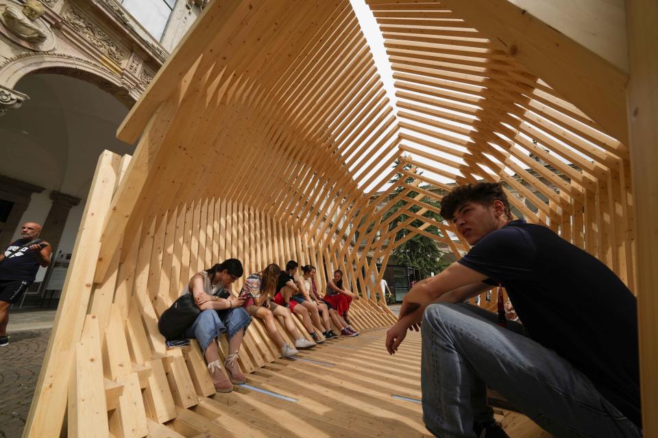 Visitors enjoy 'Echinoidea Biophilic Pavillion' by Giacomo Garziano and Rubner Haus designers, part of the 'Fuorisalone' during the Design Fair exhibition, at the Statale University courtyard, in Milan, Italy, Wednesday, June 8, 2022. The Milan furniture and design week fair is a six-day event which ends next Sunday. (AP Photo/Luca Bruno)