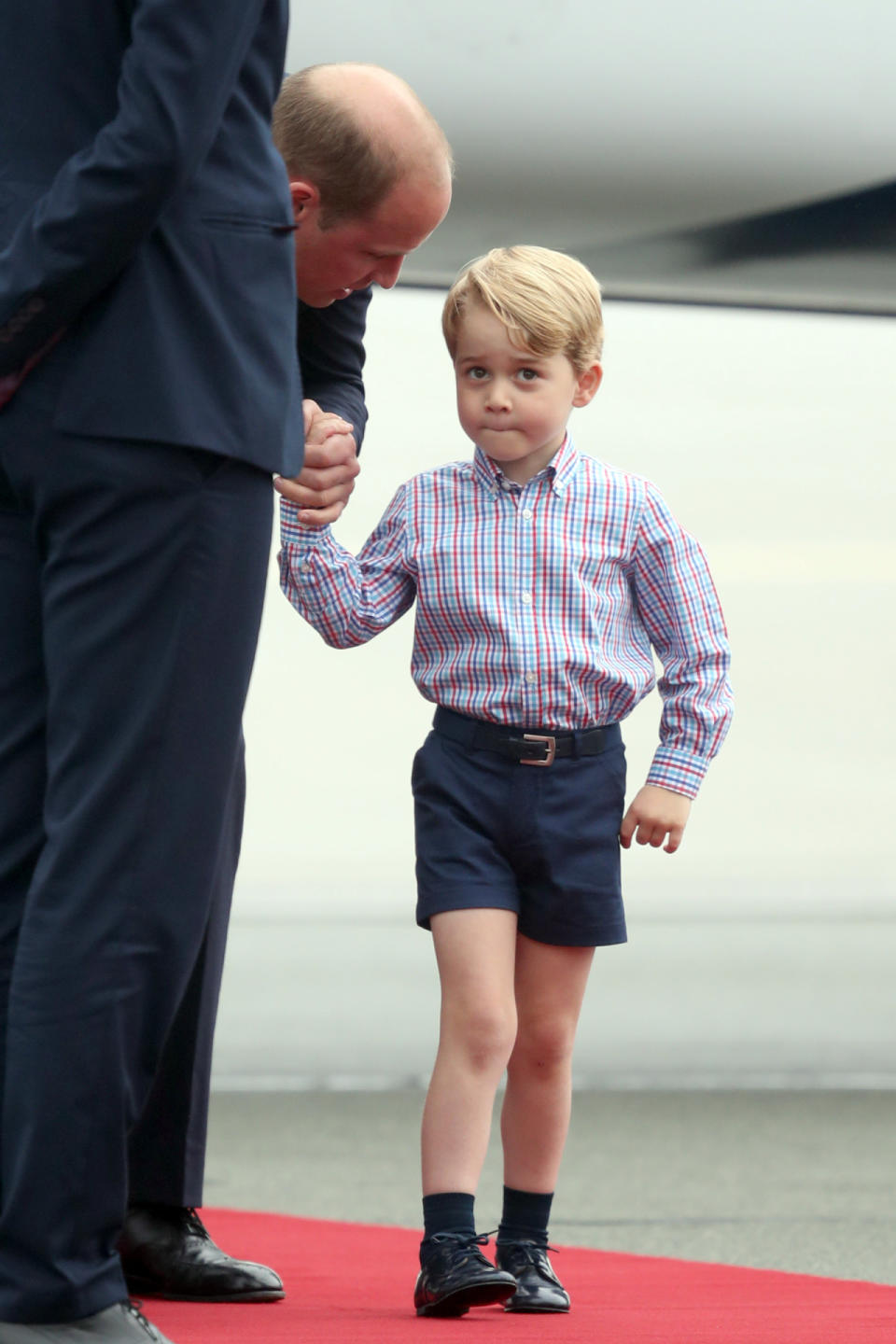 Prince George held his father’s hand tightly as he disembarked from the plane in Warsaw, Poland, on day one of the July 2017 royal tour. 