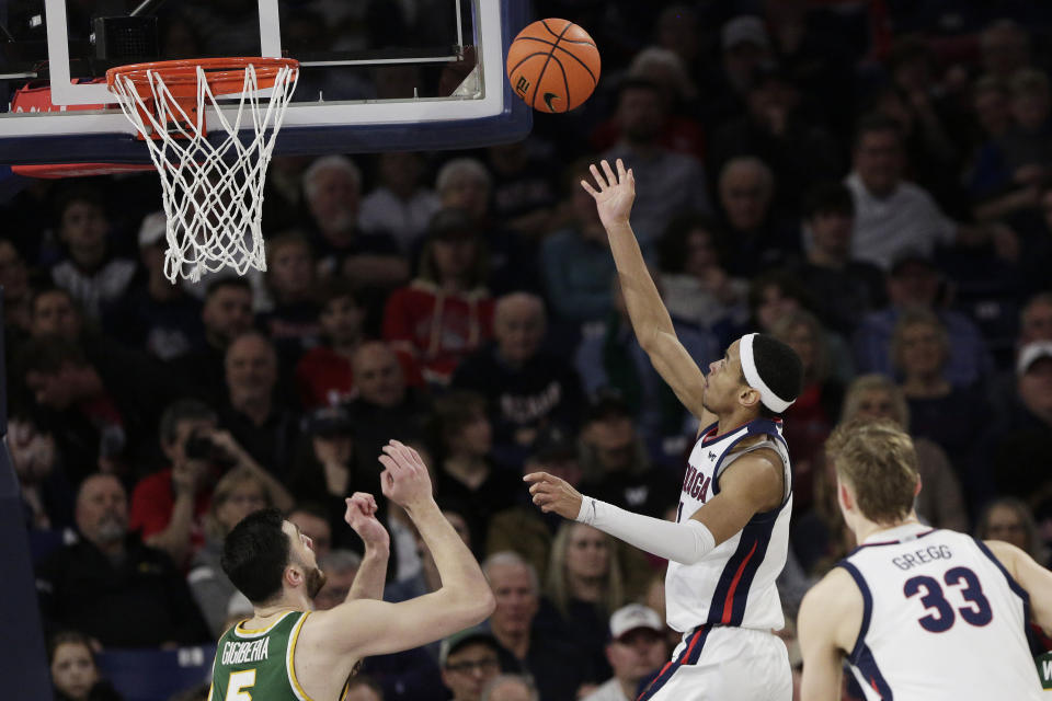 Gonzaga guard Nolan Hickman, second from right, shoots next to San Francisco center Saba Gigiberia during the second half of an NCAA college basketball game, Thursday, Feb. 9, 2023, in Spokane, Wash. (AP Photo/Young Kwak)
